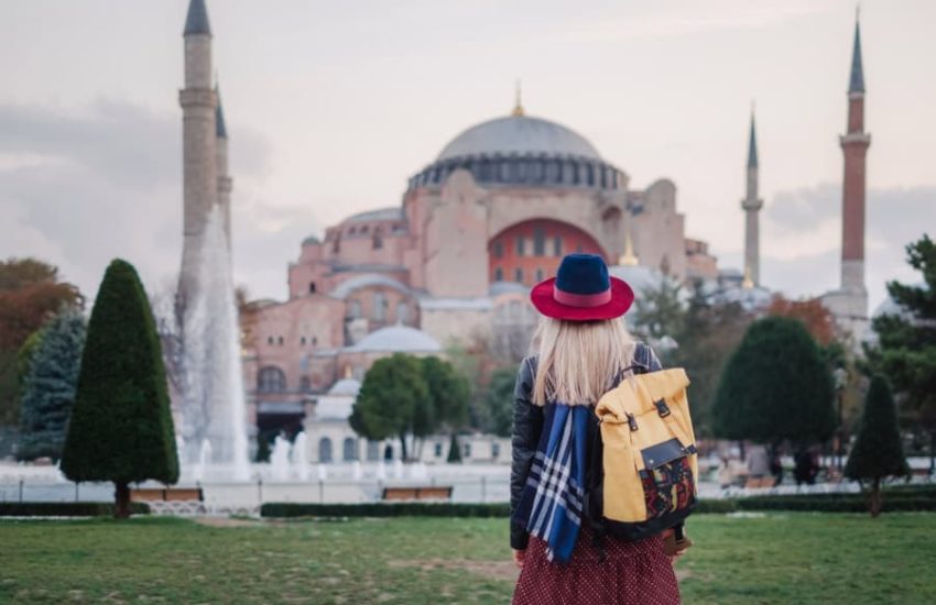 blonde girl standing across hagia sophia in istanbul. moving to Turkey or living in Turkey